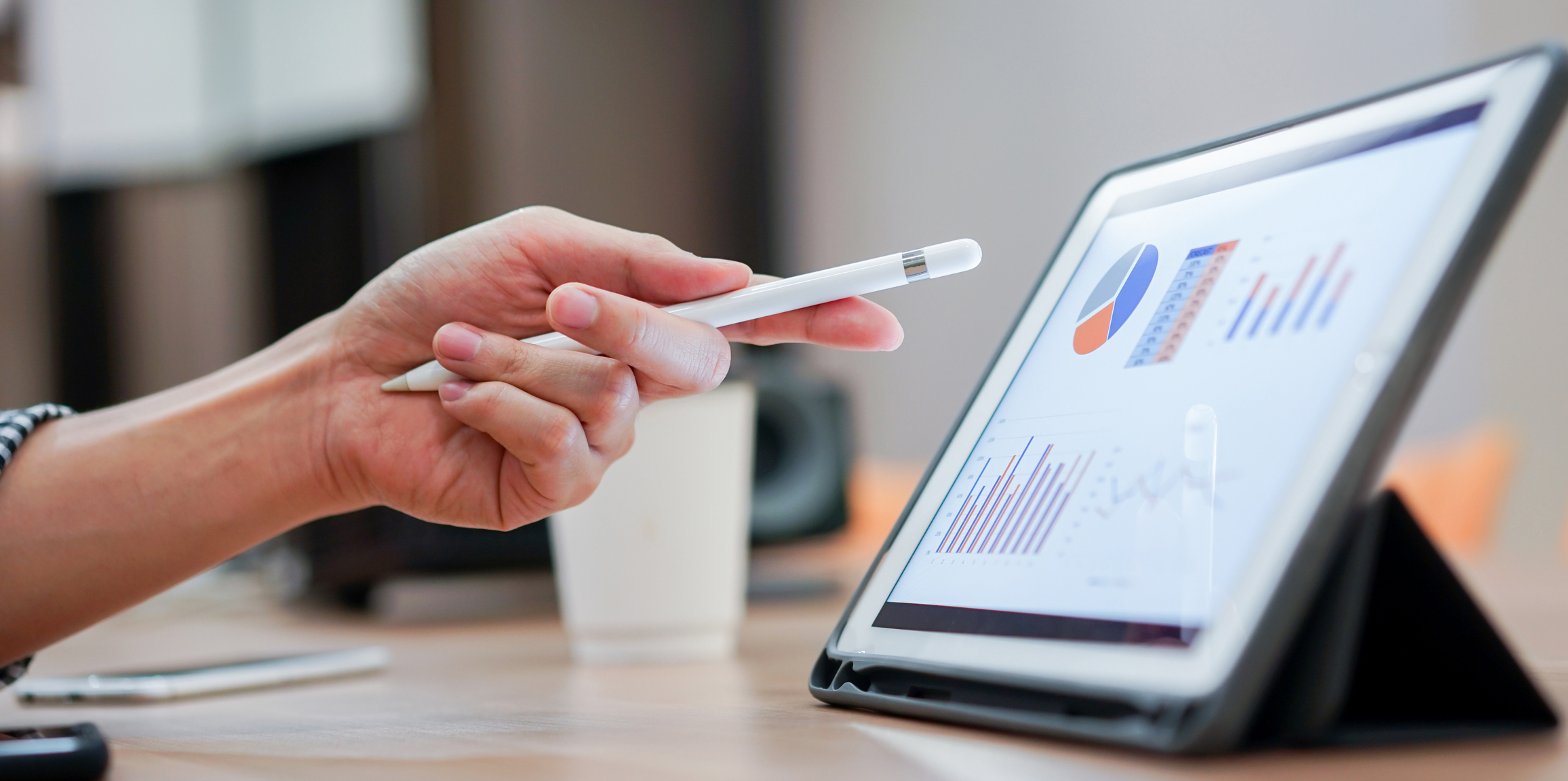 Image of hand pointing to tablet showing a graph