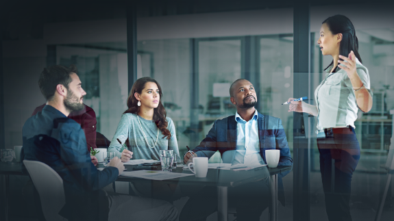 A groups of workers listening to female boss.